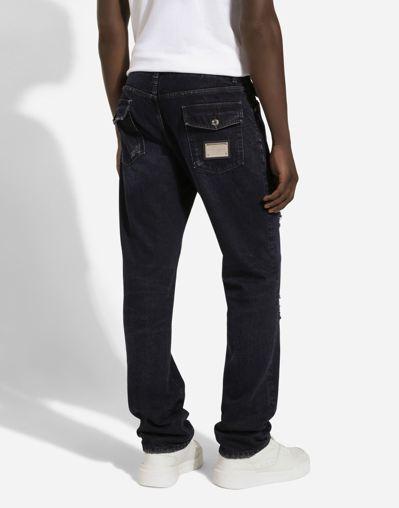 Blue denim jeans with abrasions and rips 4