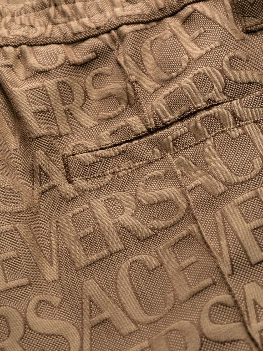 Allover logo-print cargo trousers - 7