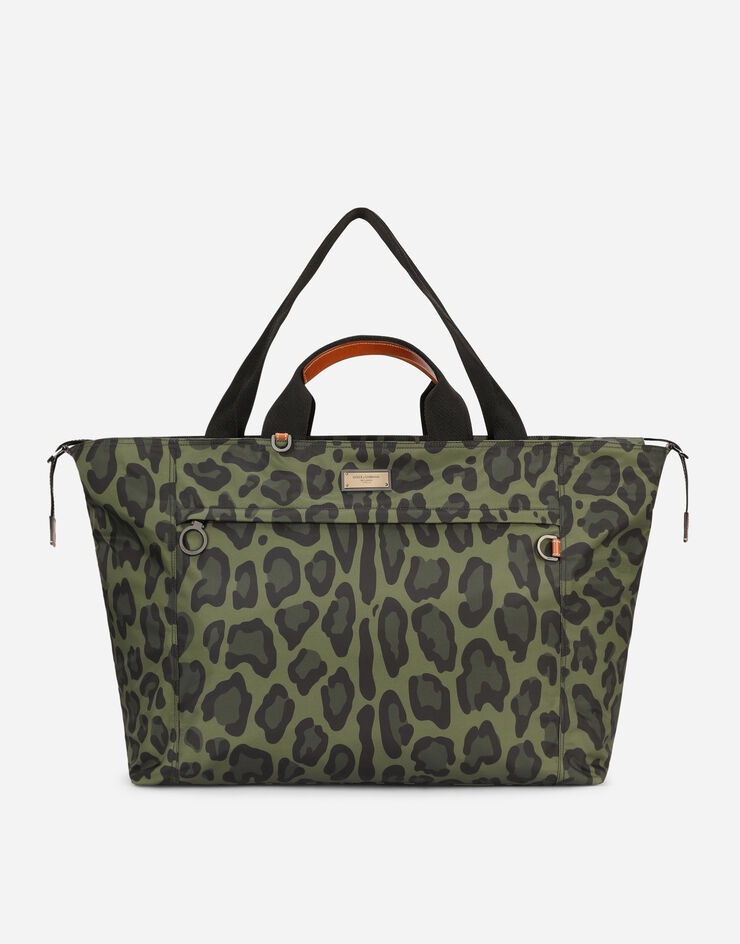 Nylon travel bag with leopard print against a green background and branded plate - 1