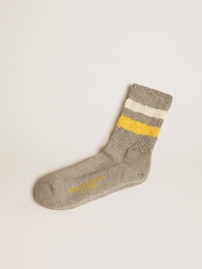 Gray socks with distressed details and yellow and white stripes 1