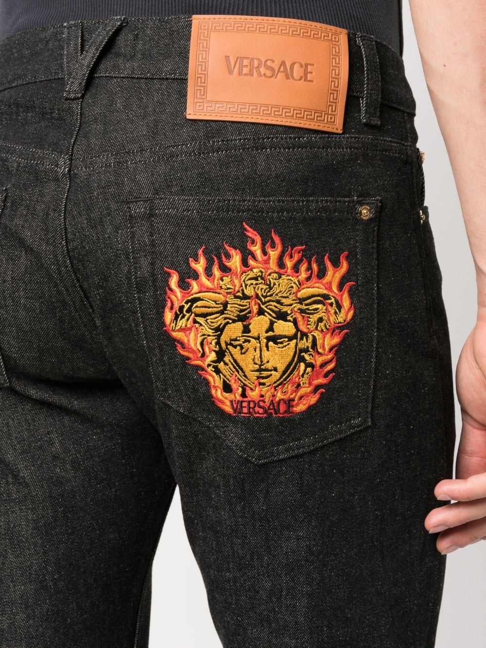 Medusa-embroidered slim-fit jeans - 5