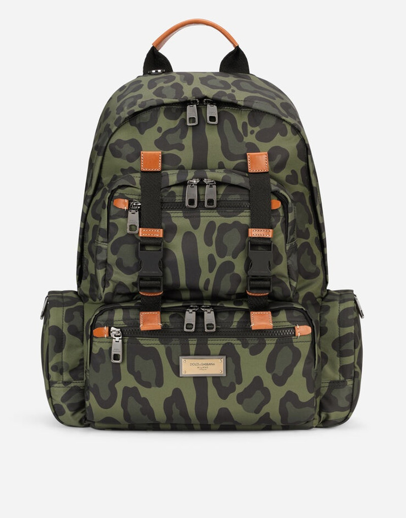 Nylon backpack with leopard print against a green background and branded plate 1