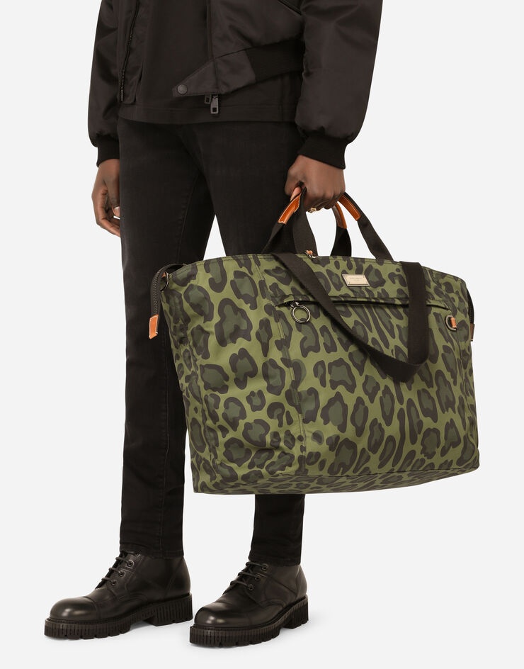 Nylon travel bag with leopard print against a green background and branded plate - 6