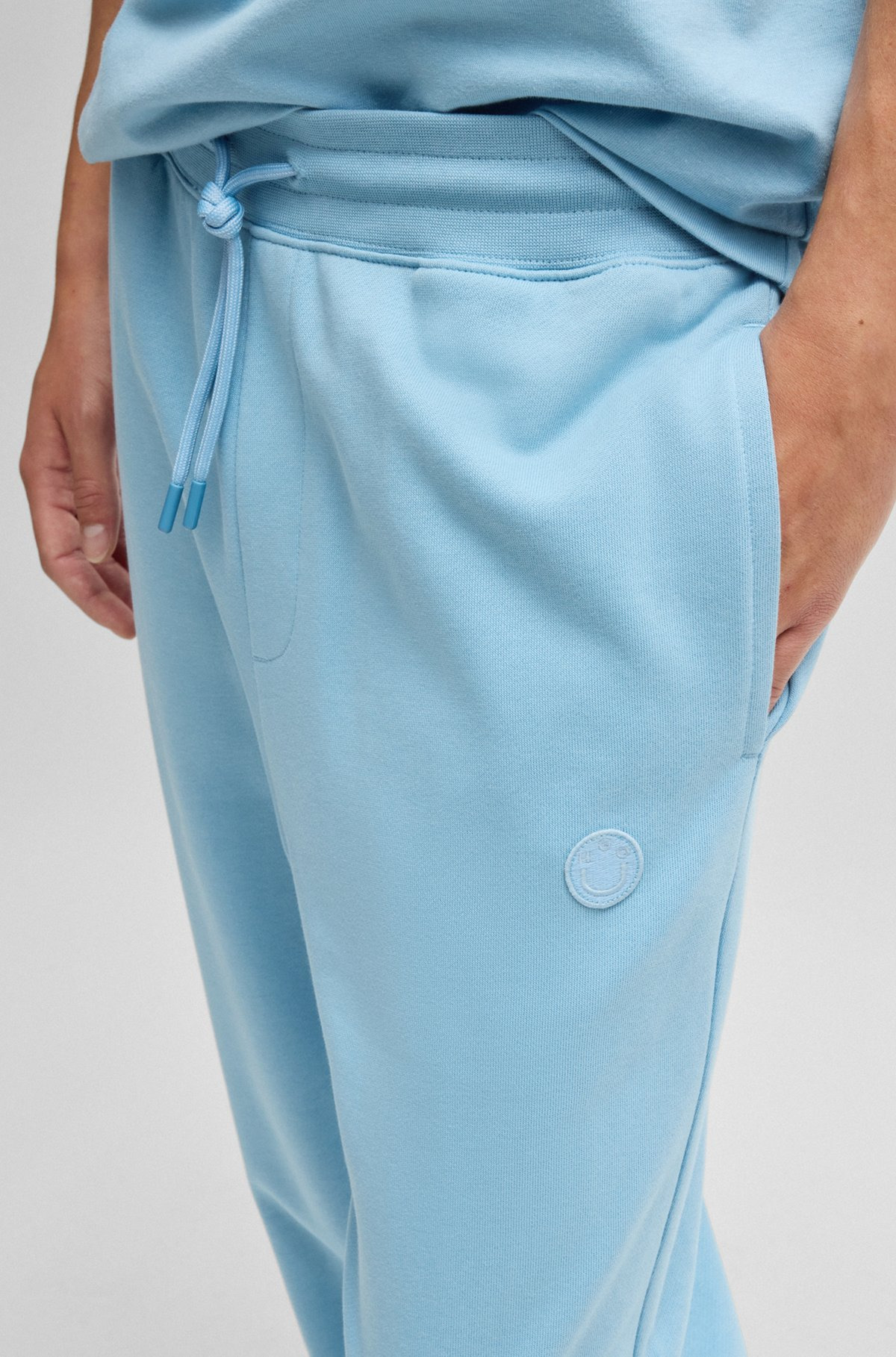 COTTON-TERRY TRACKSUIT BOTTOMS WITH HAPPY HUGO LOGO PATCH - 3