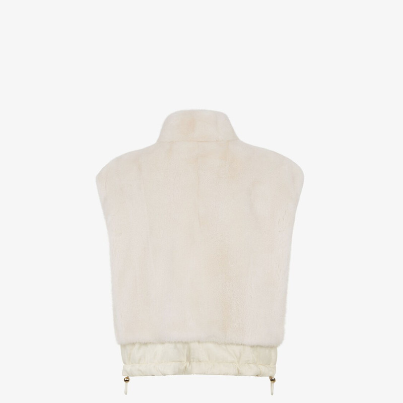 Short reversible vest with high collar and drawstring hem. One side has zipper pockets, the other hi 2