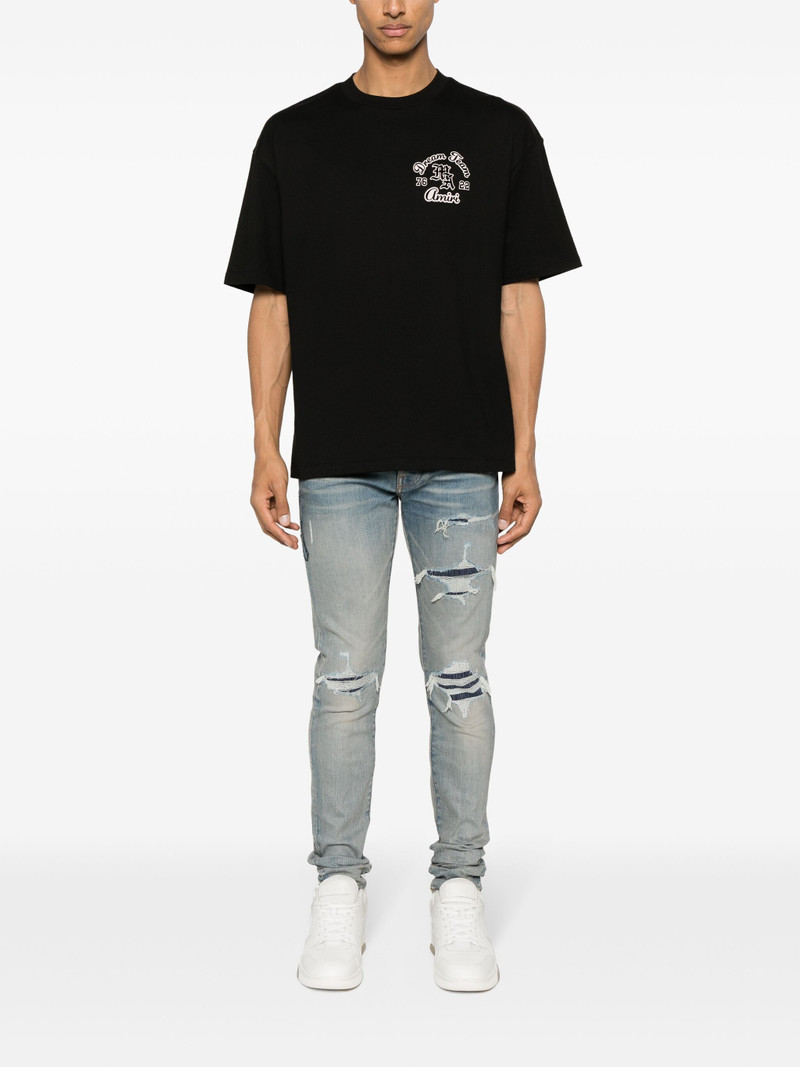 AMIRI logo-patch ripped skinny jeans outlook