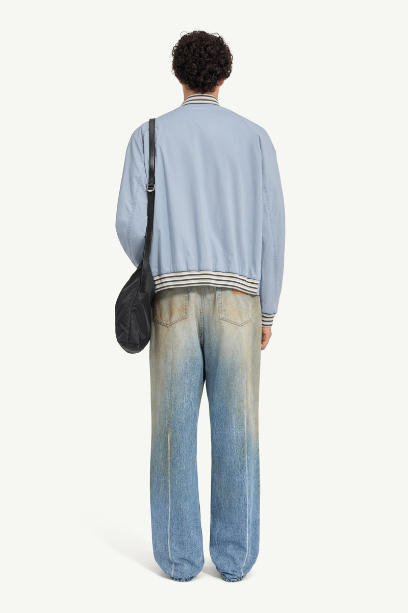 A classic varsity silhouette refined through a softened structure. The jacket balances utilitarian c 3