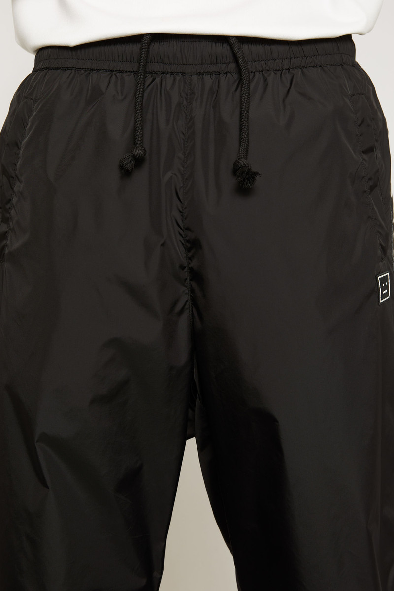 Face motif stripe track pants black 4