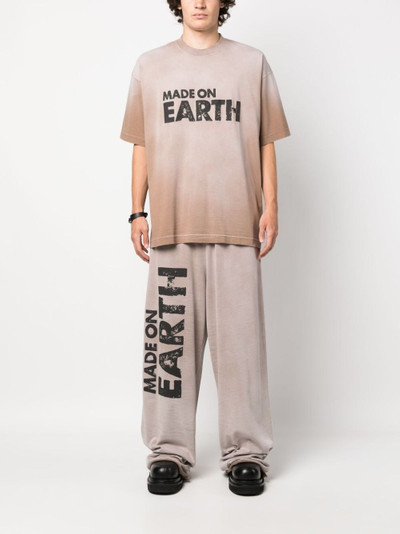 VETEMENTS slogan-print cotton track pants outlook