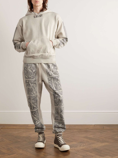 SAINT M×××××× + Denim Tears Tapered Printed Distressed Cotton-Jersey Sweatpants outlook