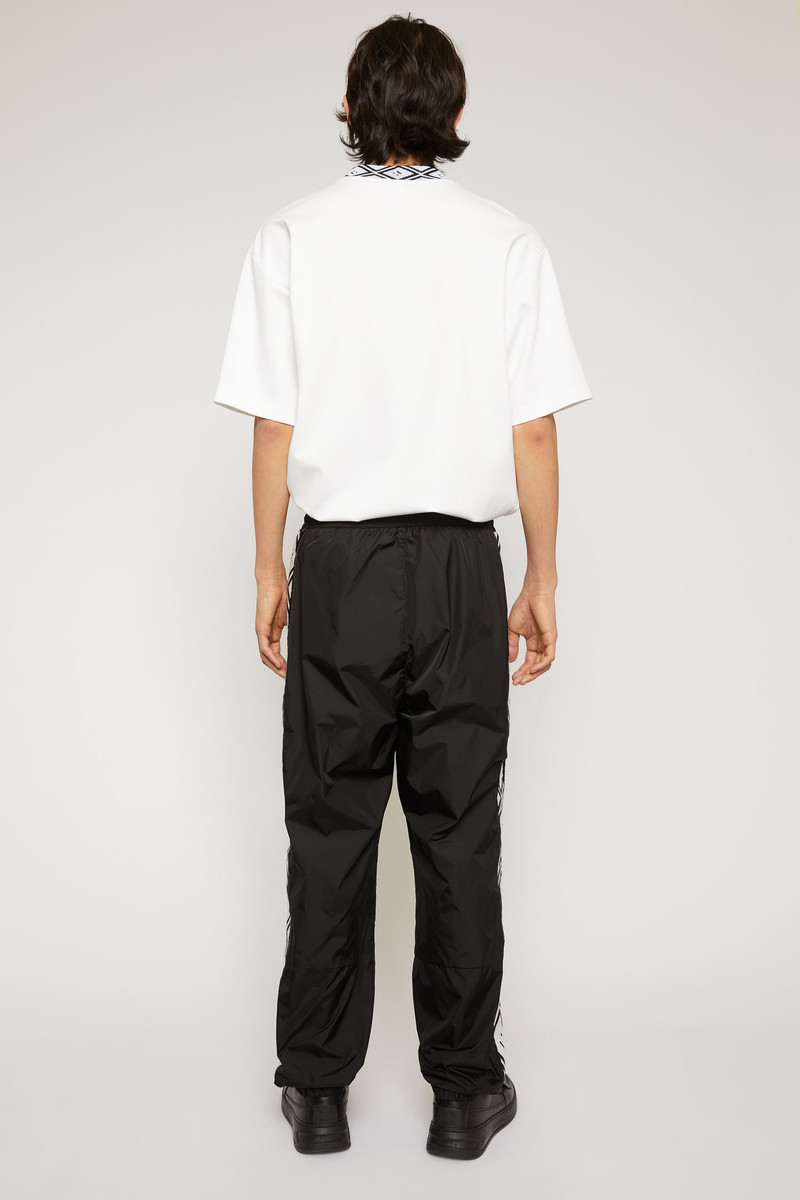 Face motif stripe track pants black 5