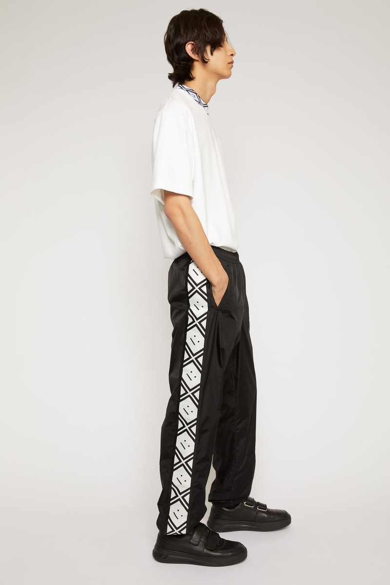 Face motif stripe track pants black 3