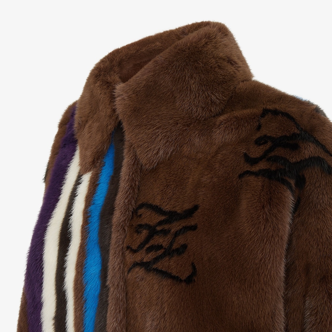 Pea coat with shirt collar, side slits and concealed button closure. Made of brown mink. Inlaid with - 3