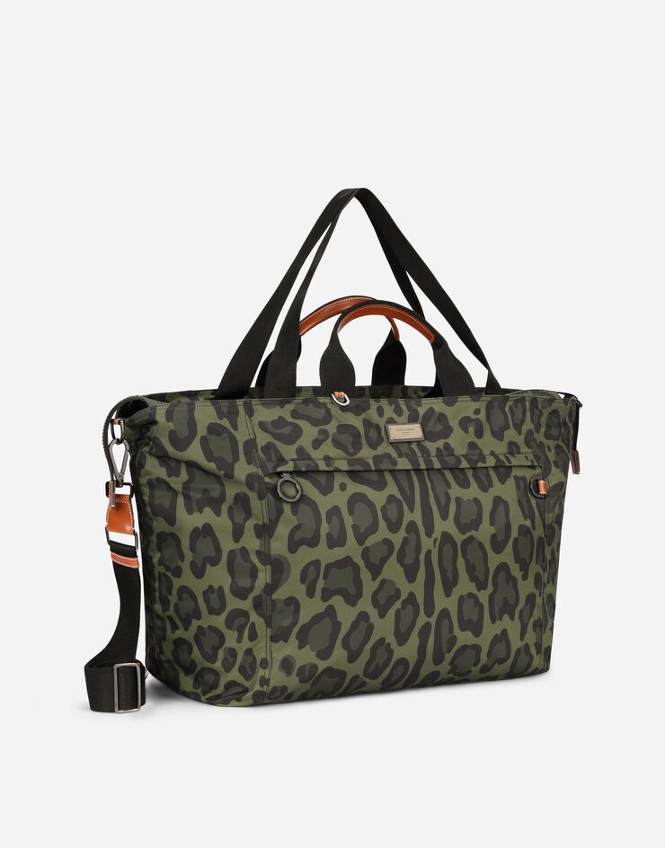 Nylon travel bag with leopard print against a green background and branded plate - 3