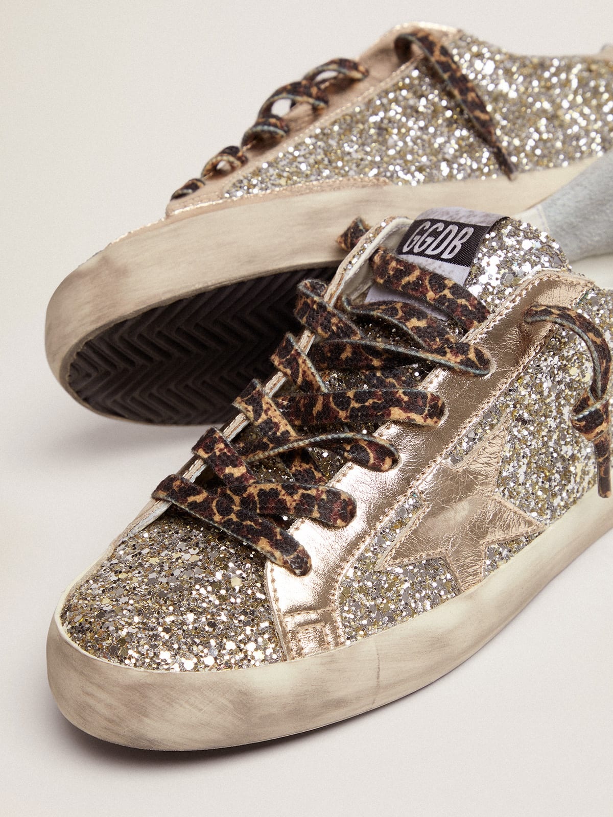 Golden Goose Super-Star sneakers in platinum-colored glitter with star and heel  tab in tone-on-tone laminated lea | REVERSIBLE