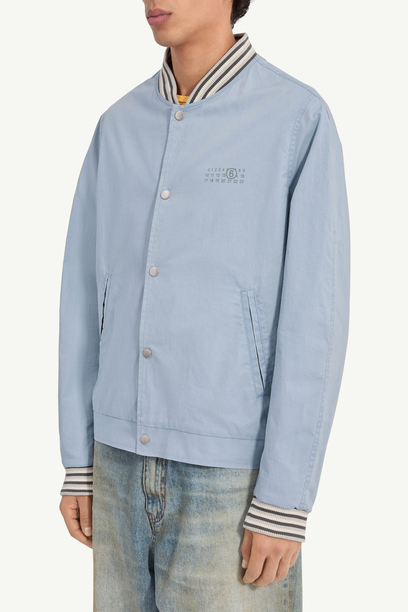 A classic varsity silhouette refined through a softened structure. The jacket balances utilitarian c 4