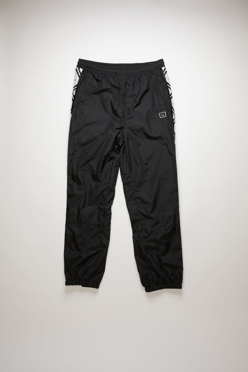 Face motif stripe track pants black 1